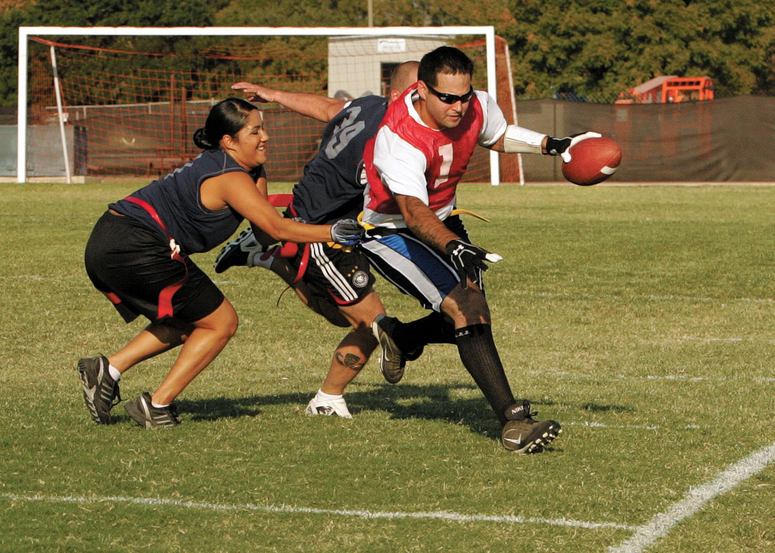37th Training Support Squadron quarterback Jaime Rivera battles through Defense Language Institute defenders to get his team in position for a touchdown. (U.S. Air Force photo/Robbin Cresswell)