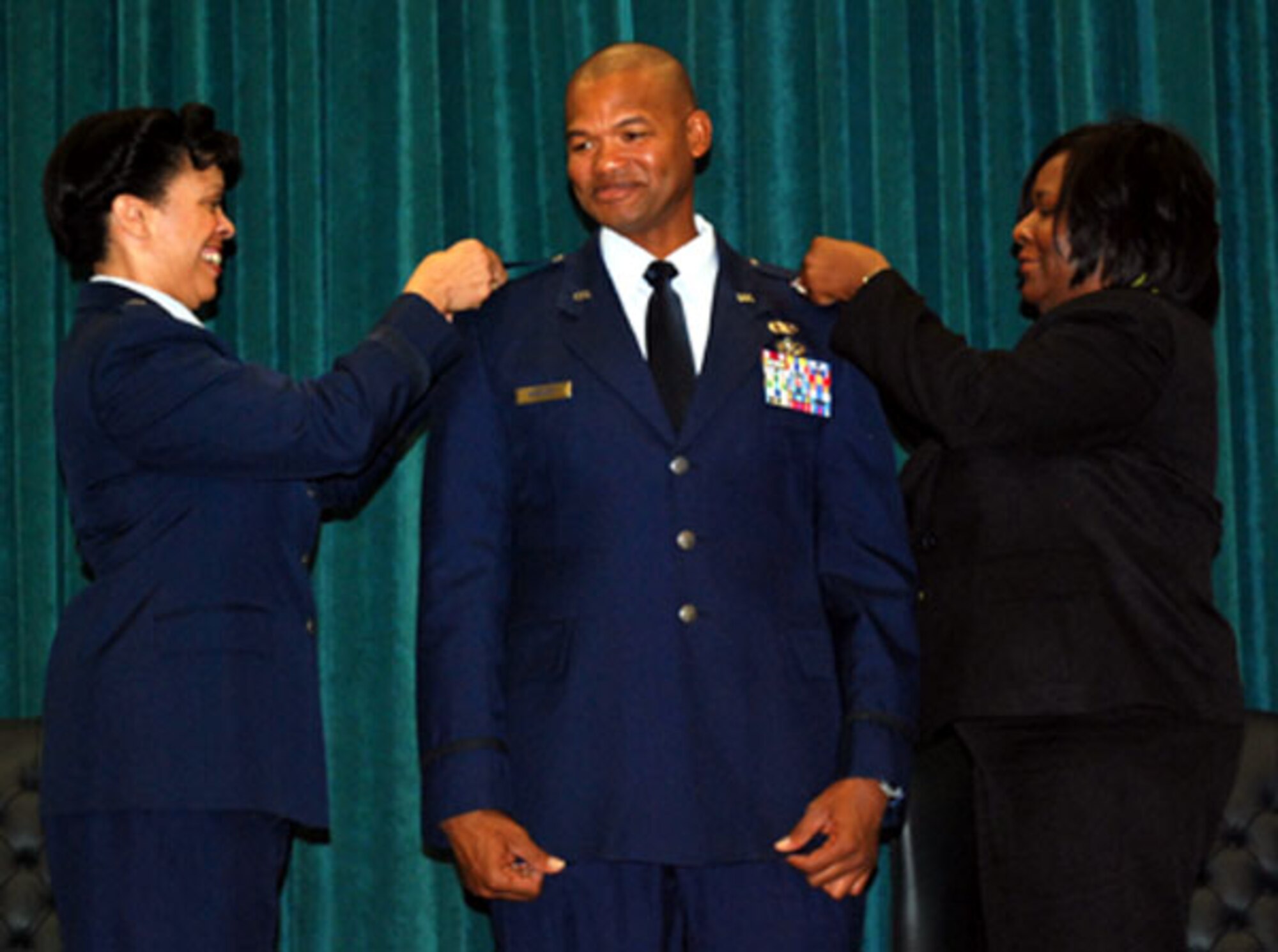 Brig. Gen. Stacey D. Harris, former vice commander of the 507th ARW and current mobilization assistant to the Commander, U.S. Africa Command and Maj Walker’s wife Jasama pin oak leafs on the major at his promotion ceremony Sept 10, 2011, at Tinker Air Force Base, OK.  Maj. Ben Walker, freight officer for the 72nd Aerial Port Squadron is currently completing training at the Oklahoma City Air Logistics Center in the Air Force Logistics Career Broadening Program.