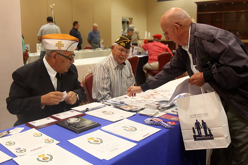 Robert Reid (right), a retired staff sergeant, reaches for a brochure during Camp Pendleton's 18th Annual Military Retiree Expo at the base's South Mesa Club, Sept. 17. The expo, which was sponsored by Marine Corps Community Services, featured various vendors who offered information to the retirees and their family members to help them throughout the course of their retirement.