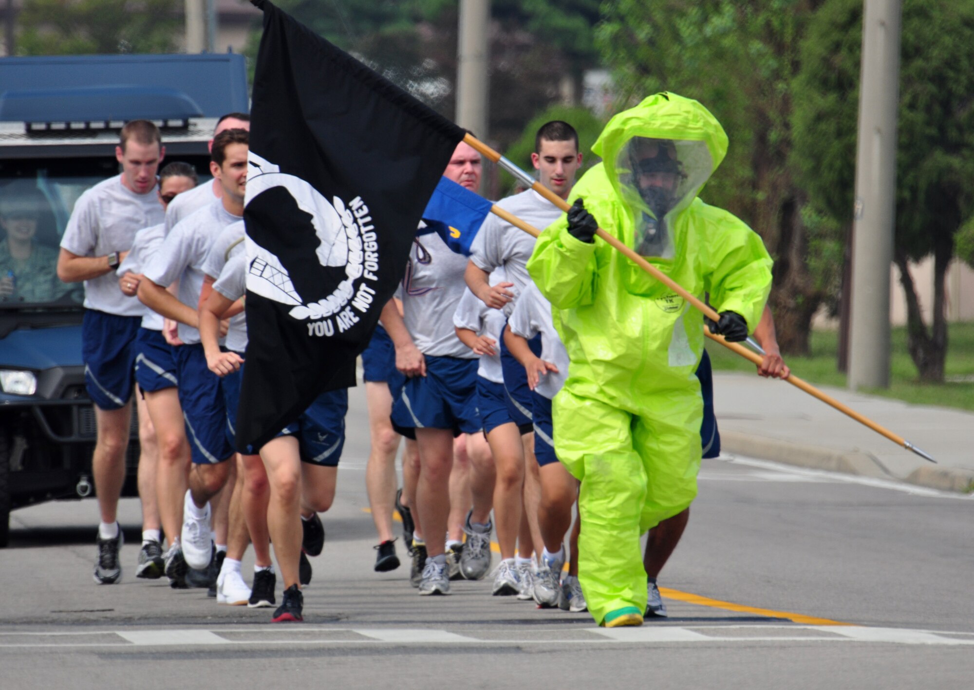 Senior Airman Destry Swadowski, 51st Civil Engineer Squadron with the emergency management flight, carries the POW/MIA flag in his HAZMAT suit Sept. 16, 2011 during the POW/MIA 24-hour run. The POW/MIA flag was carried non-stop by runners around a 1.2-mile course to honor all those who are POW/MIA and to remember those who are still missing today. Members of the Osan’s Air Force Sergeants Association honored all POW/MIAs during several ceremonies and events Sept. 12-16. (U.S. Air Force photo/Tech. Sgt. Chad Thompson)