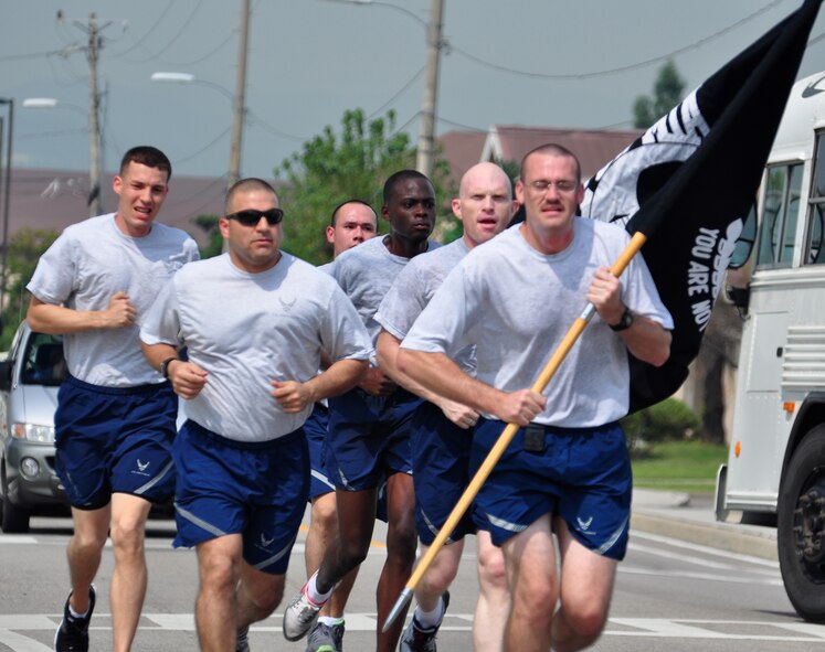 Airmen run carrying the POW/MIA flag Sept. 16, 2011 during the POW/MIA 24-hour run. The POW/MIA flag was carried non-stop by runners around a 1.2-mile course to honor all those who are POW/MIA and to remember those who are still missing today. Members of the Osan’s Air Force Sergeants Association honored all POW/MIAs during several ceremonies and events Sept. 12-16. (U.S. Air Force photo/Tech. Sgt. Chad Thompson)