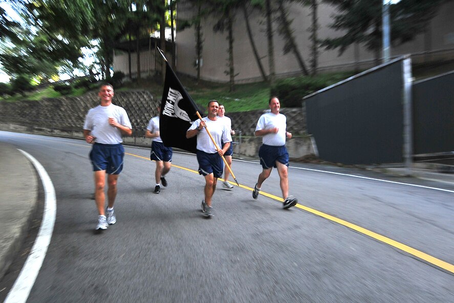 Col. Patrick McKenzie, Chief Master Sgt. Deno Mackin and Col. Mark DeLong, 51st Fighter Wing leadership, carry the POW/MIA flag for the first leg of the POW/MIA 24-hour run Sept. 15, 2011. The POW/MIA flag was carried non-stop by runners around a 1.2-mile course to honor all those who are POW/MIA and to remember those who are still missing today. Members of the Osan’s Air Force Sergeants Association honored all POW/MIAs during several ceremonies and events Sept. 12-16. (U.S. Air Force photo/Senior Airman Adam Grant)