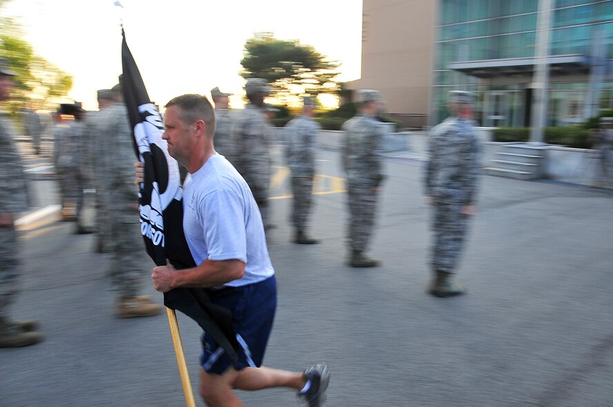 Chief Master Sgt. Deno Mackin, 51st Fighter Wing Command Chief, begins the POW/MIA 24-hour run Sept. 15, 2011, at the base flagpole. The POW/MIA flag was carried non-stop by runners around a 1.2-mile course to honor all those who are POW/MIA and to remember those who are still missing today. Members of the Osan’s Air Force Sergeants Association honored all POW/MIAs during several ceremonies and events Sept. 12-16. (U.S. Air Force photo/Senior Airman Adam Grant)