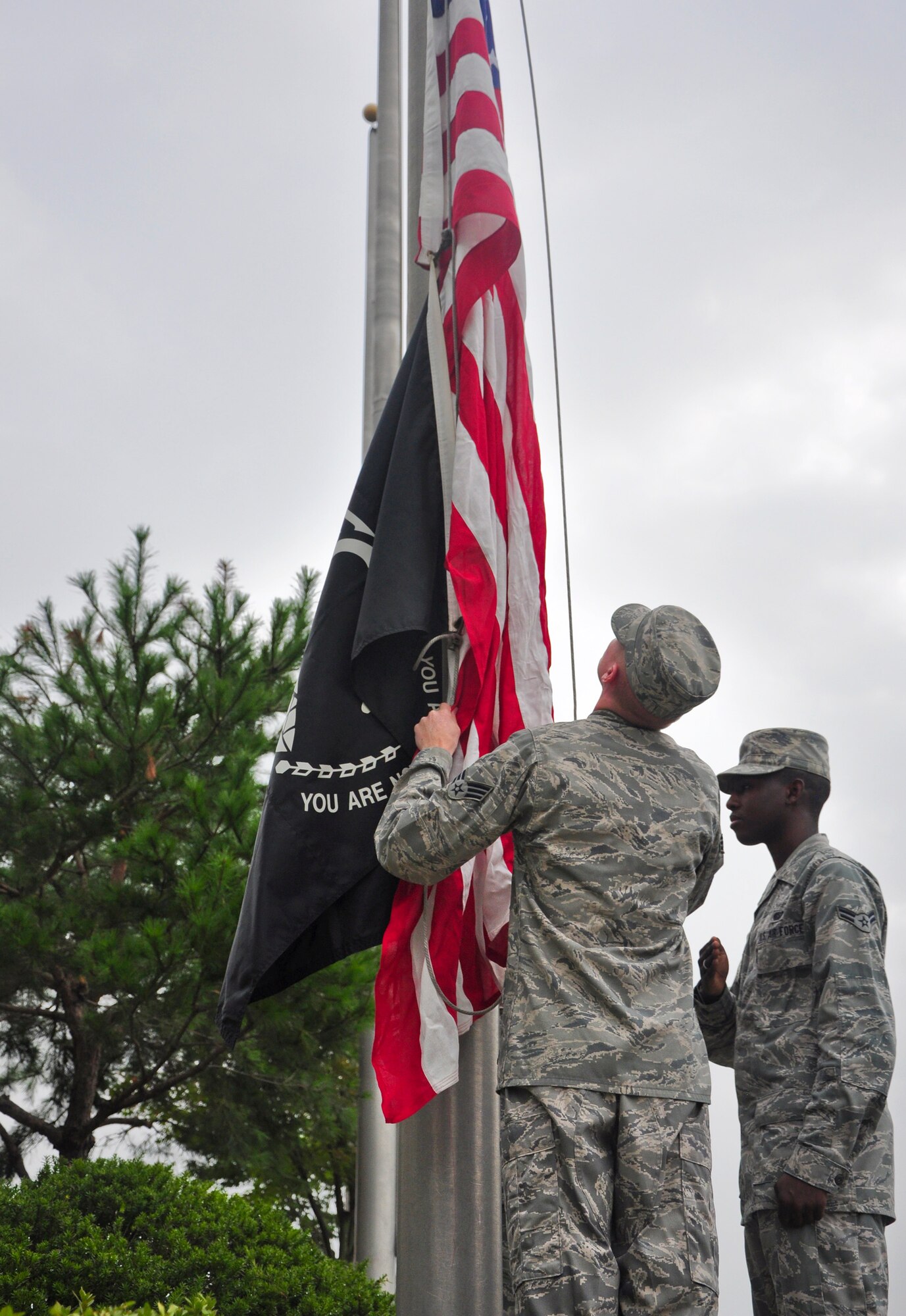 Airmen with the base honor guard raise the American flag and the POW/MIA flag Sept. 12 at the base flagpole. About 100 Airmen formed up at the 51st Fighter Wing headquarters building for the ceremony to formally start a week honoring all the prisoners of war and those still missing in action. Members of the Osan’s Air Force Sergeants Association honored all POW/MIAs during several ceremonies and events Sept. 12-16. (U.S. Air Force photo/Tech. Sgt. Chad Thompson)