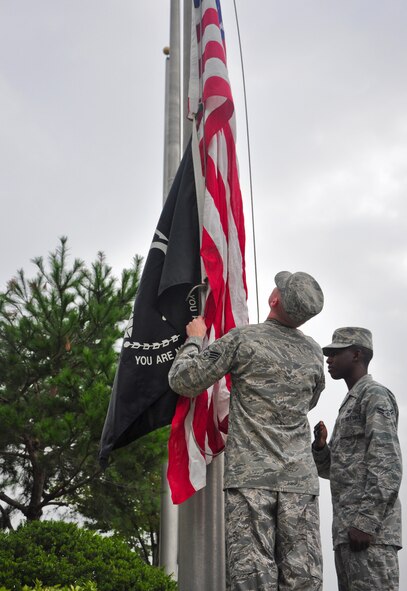 Airmen with the base honor guard raise the American flag and the POW/MIA flag Sept. 12 at the base flagpole. About 100 Airmen formed up at the 51st Fighter Wing headquarters building for the ceremony to formally start a week honoring all the prisoners of war and those still missing in action. Members of the Osan’s Air Force Sergeants Association and Veterans of Foreign Wars chapter honored all POW/MIAs during several ceremonies and events Sept. 12-16. (U.S. Air Force photo/Tech. Sgt. Chad Thompson)