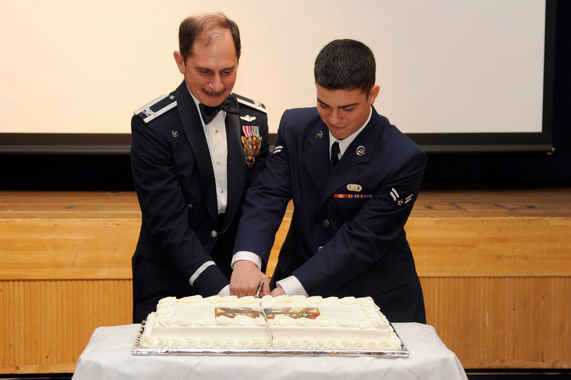 MISAWA AIR BASE, Japan -  Col. Terry Haske, 35th Medical Group commander, and Airman 1st Class Michael Ruggeri, 35th Force Support Squadron, prepare to cut the official cake commemorating the Air Force's 64th anniversary during the annual Misawa Air Base Air Force Ball here Sept. 17. Tradition dictates the oldest and youngest Air Force members join together to cut the cake. (U.S. Air Force photo/Tech. Sgt. Marie Brown)