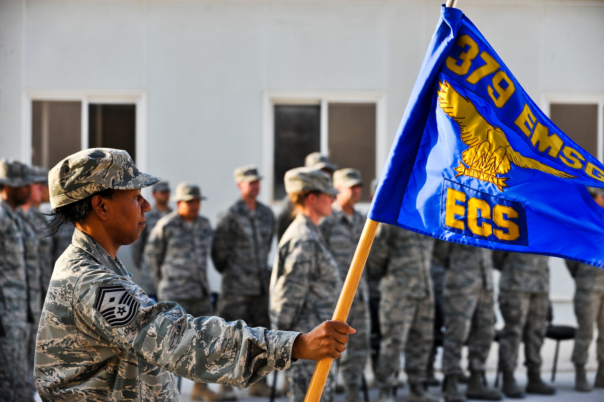Senior Master Sgt. Juanita Crain, 379th Expeditionary Communications Squadron first sergeant, holds the 379th ECS guidon during a retreat ceremony, Sept. 16, 2011, at an undisclosed location in Southwest Asia. The retreat marked the final event of Cyber Awareness Week, Sept. 11-16. The week was developed to increase awareness among the base population regarding cyber threats and hackers and to educate individuals about personal responsibilities, such as risk mitigation at work and home. Crain, a native of Crestview, Fla., is deployed from Eglin Air Force Base, Fla. (U.S. Air Force photo/Senior Airman Paul Labbe)