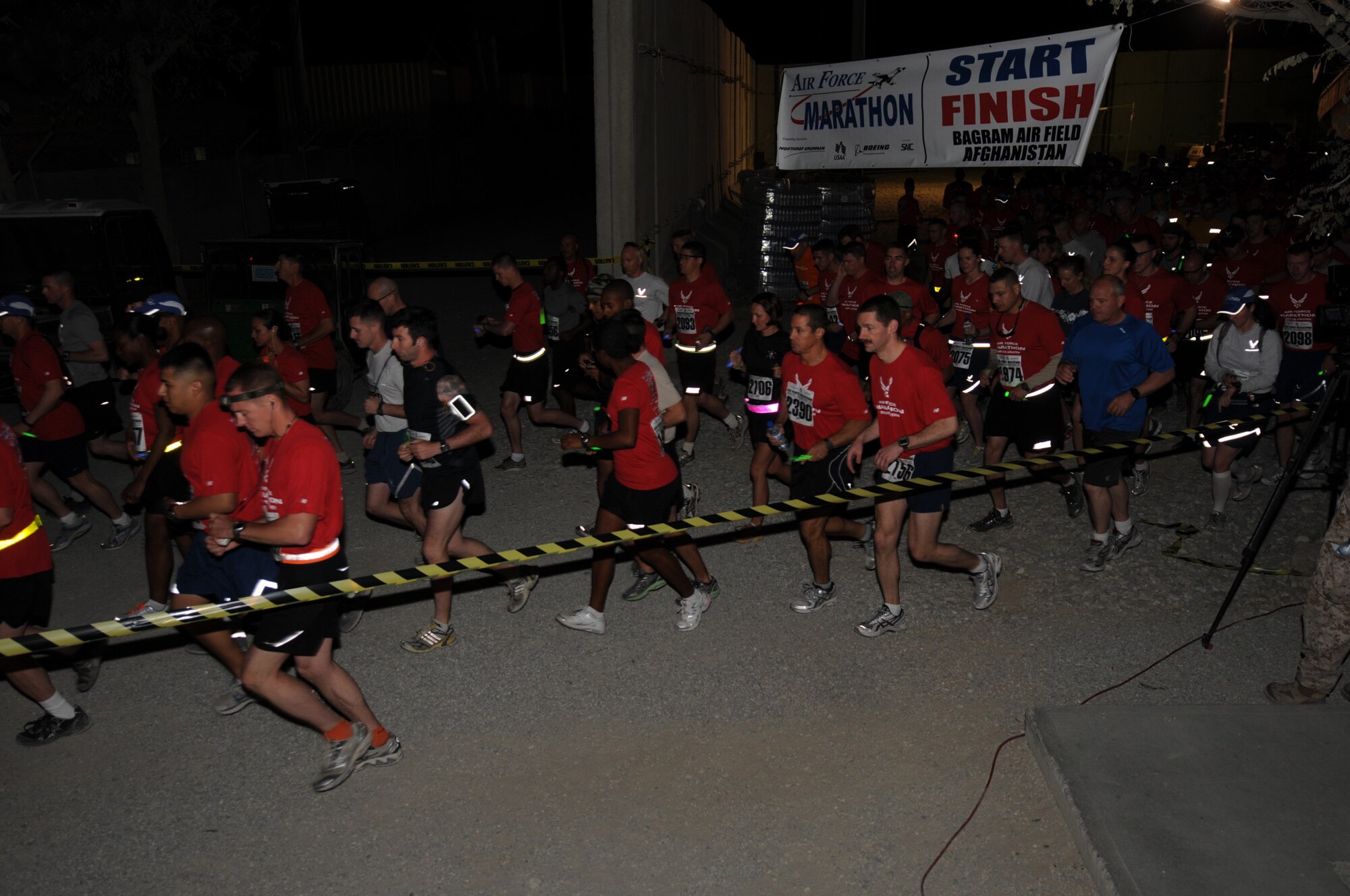 BAGRAM AIRFIELD, Afghanistan -- Contestants take off from the starting line of the Air Force Marathon held here Sept. 17, 2011. The official Air Force marathon is held each year at Wright-Patterson Air Force Base; however, organizers at Bagram Airfield ensure deployed members have the opportunity to participate in the popular event by holding an equally challenging marathon at Bagram Airfield. The event is held the third Saturday in September each year in celebration of the U.S. Air Force birthday.  This year, the Air Force turned 64 years old.  (U.S. Air Force photo/Senior Airman Krista Rose)