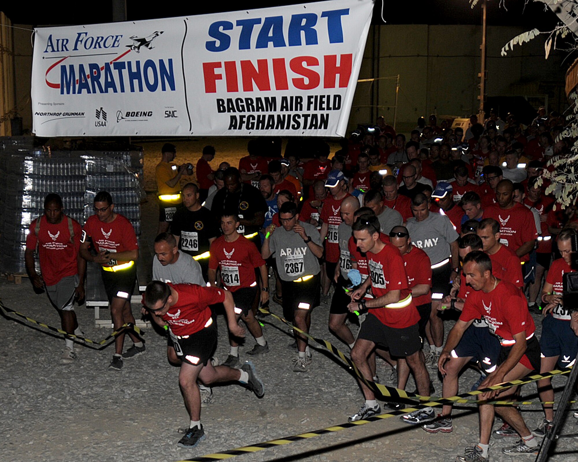 BAGRAM AIRFIELD, Afghanistan -- Contestants take off from the starting line of the Air Force Marathon held here Sept. 17, 2011. The official Air Force marathon is held each year at Wright-Patterson Air Force Base; however, organizers at Bagram Airfield ensure deployed members have the opportunity to participate in the popular event by holding an equally challenging marathon at Bagram Airfield. The event is held the third Saturday in September each year in celebration of the U.S. Air Force birthday.  This year, the Air Force turned 64 years old.  (U.S. Air Force photo/Senior Airman Krista Rose)
