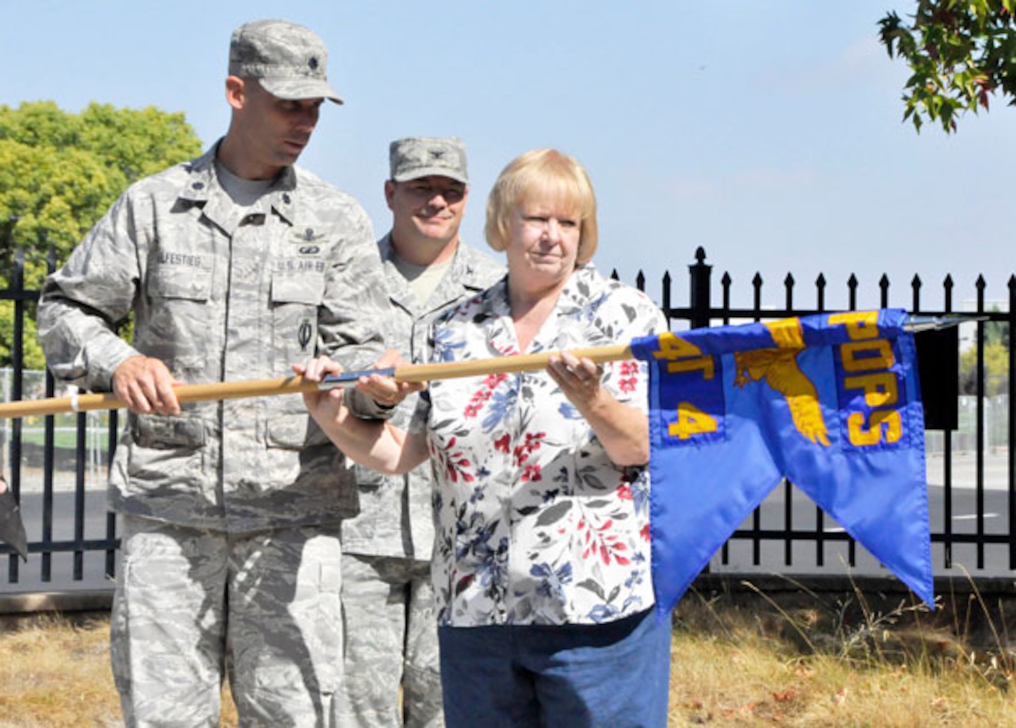 SUNNYVALE, Calif. - Lt. Col. Michael Wulfestieg, 21st Space Ops Sq commander, left, retires the flag with Ms. Rose Beemer-Jansson, 21st Space Ops Sq Chief, Det 4, at the former Onizuka Air Force Station on Sept. 15, 2011. Col. Michael Finn, Network Operations Group commander, looks on.