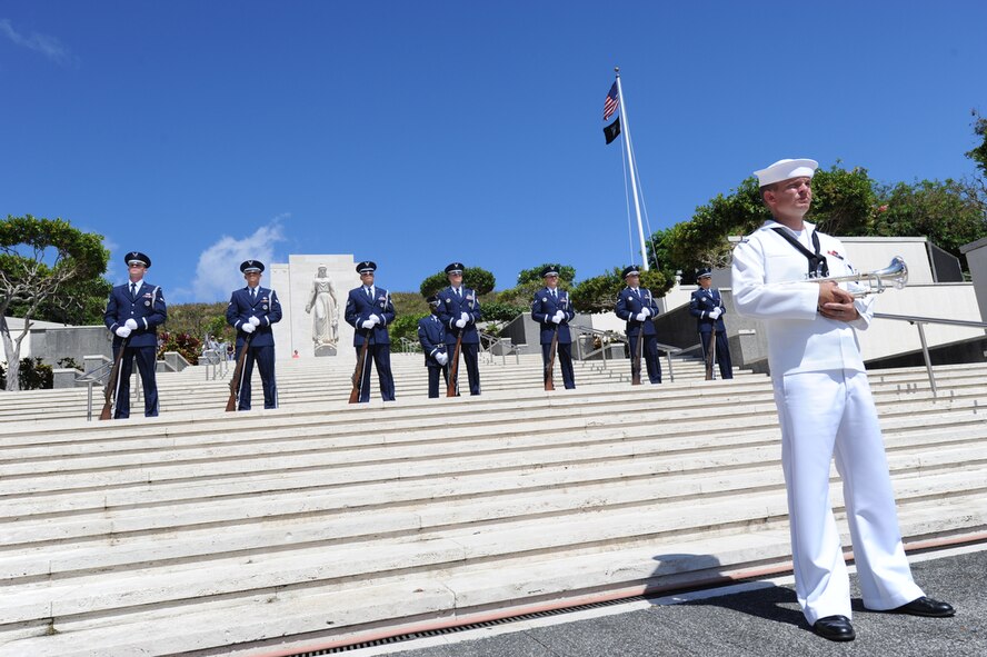 Musician 3rd Class, Shelby Tucci, a native of Huntington, W. Va., waits in the foreground of Air Force honor guard members assigned to Joint Base Pearl Harbor-Hickam, Hawaii before performing the "Taps" melody at the conclusion of the POW/MIA Recognition Day Ceremony held at the National Memorial Cemetery of the Pacific (Punchbowl) in Honolulu, Hawaii on Sept. 16.  More than 200 past and present military members and civilians gathered with the Joint POW/MIA Accounting Command (JPAC) as they honored those held in captivity or are missing in action from past conflicts.  The third Friday of Sept. has served as the National POW/MIA Recognition Day since 1986 and honors and recognizes the sacrifices of those Americans who have been prisoners of war and to remind the Nation of those individuals that are still missing.  JPAC is responsible for the recovery of missing Americans from past conflicts and travels all around the world in search of those individuals in order to bring full accountability to their families and the American people.  (DoD photo/Master Sgt. Cohen A. Young)
