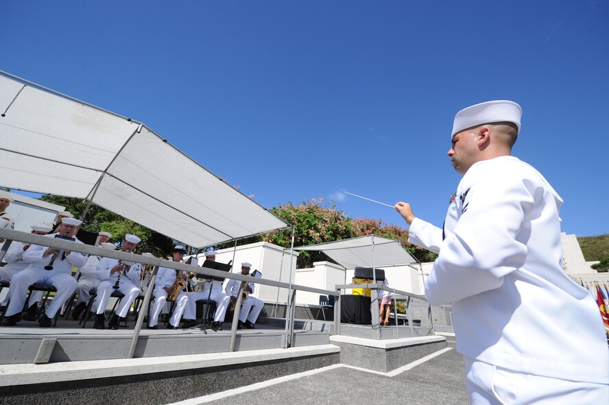 Musician 1st Class, John Wheeler leads the Pacific Fleet Band while performing at the start of the POW/MIA Recognition Day Ceremony held at the National Memorial Cemetery of the Pacific (Punchbowl) in Honolulu, Hawaii on Sept. 16.  More than 200 past and present military members and civilians gathered with the Joint POW/MIA Accounting Command (JPAC) as they honored those held in captivity or are missing in action from past conflicts.  The third Friday of Sept. has served as the National POW/MIA Recognition Day since 1986 and honors and recognizes the sacrifices of those Americans who have been prisoners of war and to remind the Nation of those individuals that are still missing.  JPAC is responsible for the recovery of missing Americans from past conflicts and travels all around the world in search of those individuals in order to bring full accountability to their families and the American people.  (DoD photo/Master Sgt. Cohen A. Young)
