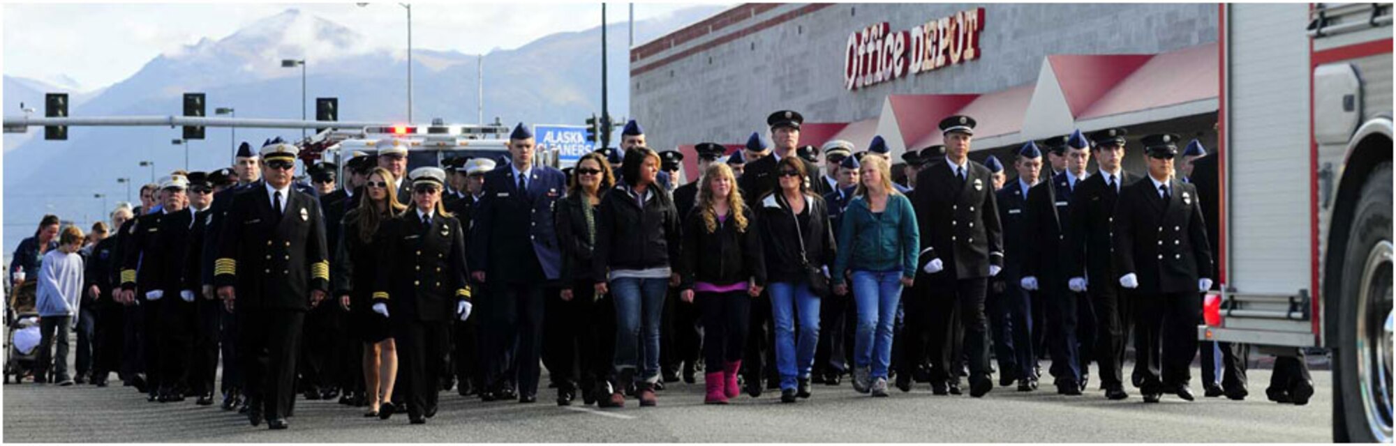 Anchorage -- Firefighters and families walk behind the lead fire engine as they make their way down 5th Avenue to the Alaska Fallen Firefighter Memorial at the corner of 5th Avenue and A Street, Sept. 11.   (U.S. Air Force photo/Percy Jones)
