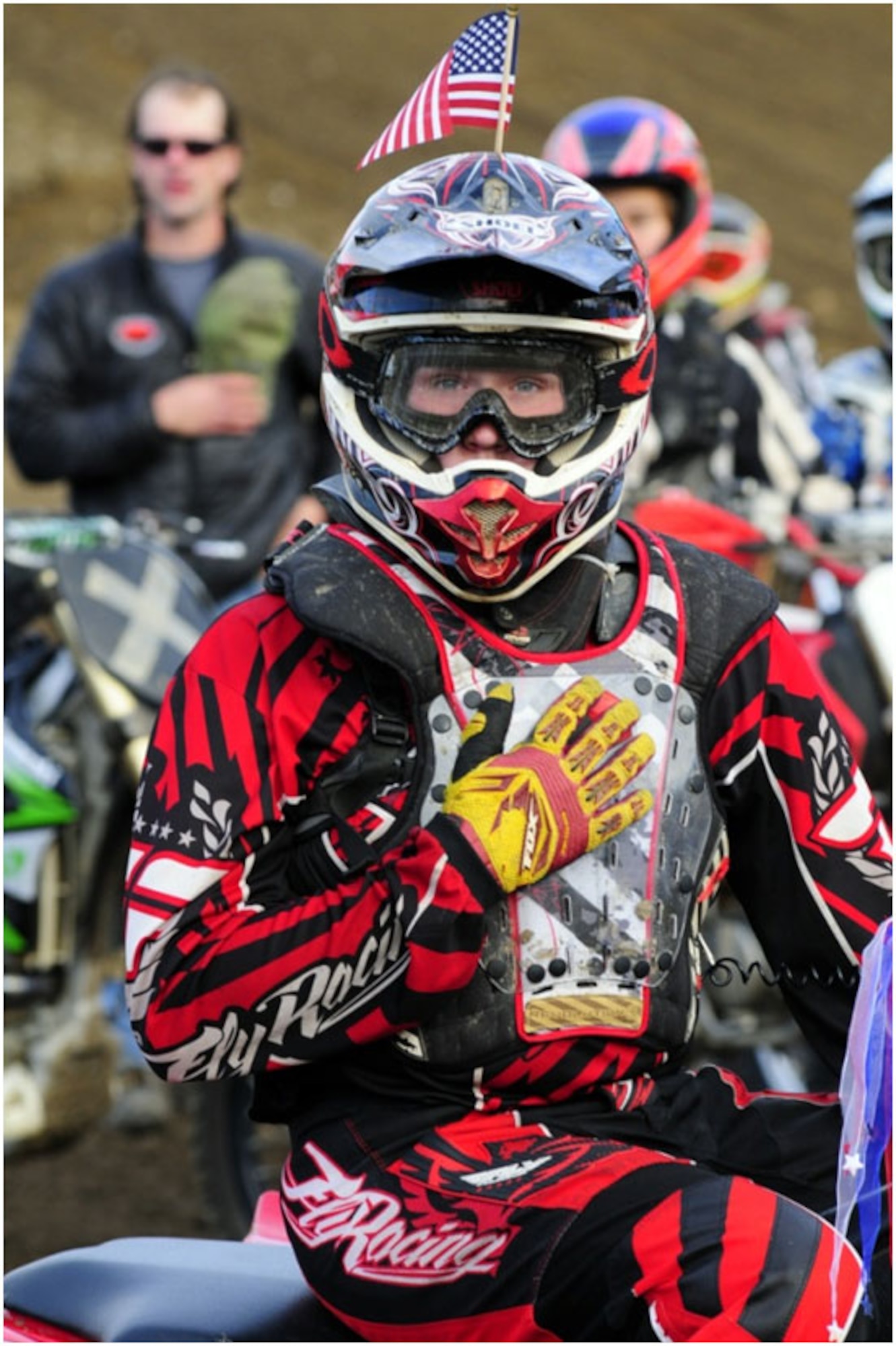 Anchorage -- A rider pays respect to the U.S. flag as the National Anthem is sung prior to the start of the September 11th Motocross Race at the Jodhpur Motocross Track Sunday.  With the Flag of Heroes, inscribed with the names of the fallen emergency responders of the September 11th, 2001 attacks leading the way, the riders participated in a ceremonial lap prior to the start of the races.. (U.S. Air Force photo/Percy Jones)