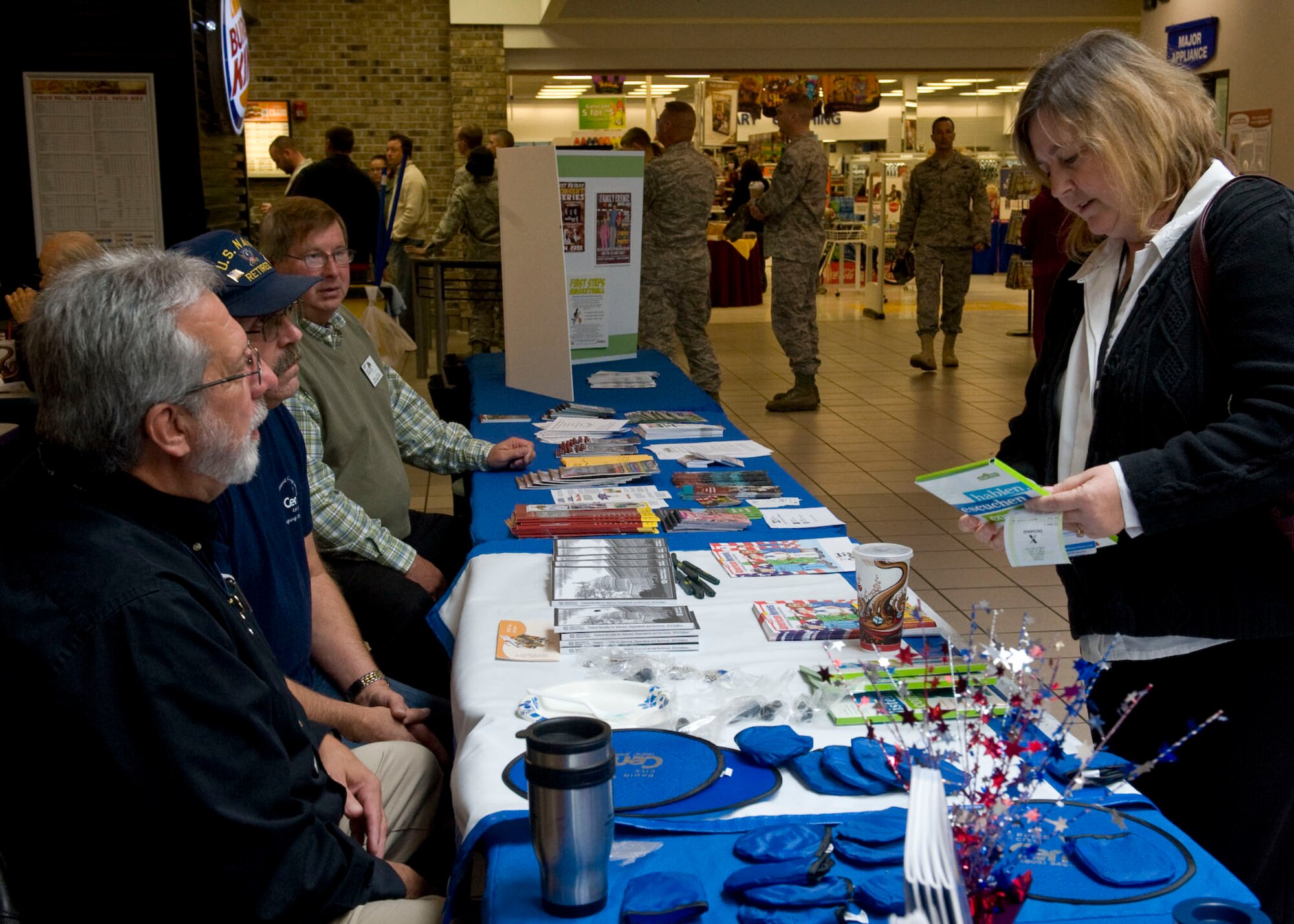 Terese Henderson, Air Force Financial Services Center, financial technician speaks with Jim Dodds, veterans service counselor, Martin Miller, readjustment counselor, and Neal Lutke, area Veterans Administrative service officer, about programs veterans and retired military members are entitled to during the Retiree Appreciation Day at the Base Exchange on Ellsworth Air Force Base, S.D., Sept. 16, 2011.  Retirees and others were able to receive the latest information on benefits and programs available for them and their families. (U.S. Air Force photo by Airman 1st Class Kate Thornton/Released) 