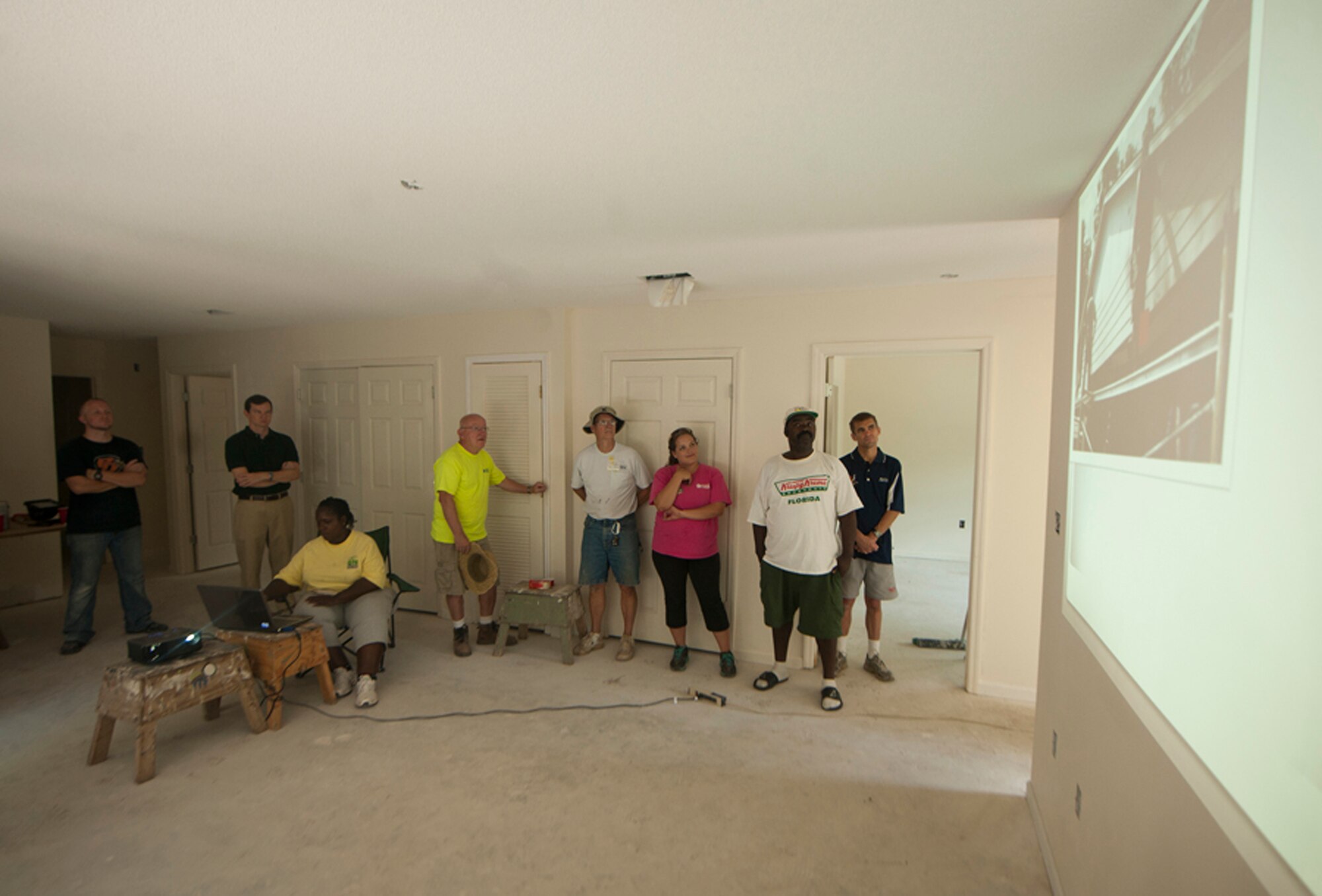 Habitat for Humanity members and Airmen from Moody Air Force Base, Ga., watch a slideshow presented at the end of the ribbon-cutting ceremony in Valdosta, Ga., Sept. 17, 2011. The slideshow was compiled of images taken throughout the week, showing the house’s progression from start to finish. (U.S. Air Force photo by Airmen 1st Class Joshua Green/Released)      
