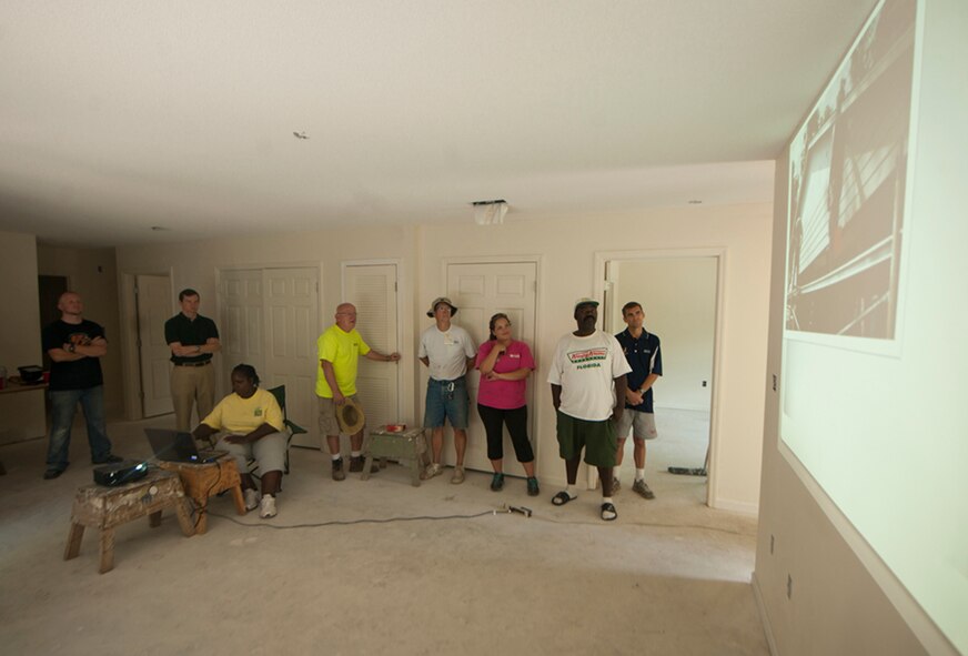 Habitat for Humanity members and Airmen from Moody Air Force Base, Ga., watch a slideshow presented at the end of the ribbon-cutting ceremony in Valdosta, Ga., Sept. 17, 2011. The slideshow was compiled of images taken throughout the week, showing the house’s progression from start to finish. (U.S. Air Force photo by Airmen 1st Class Joshua Green/Released)      
