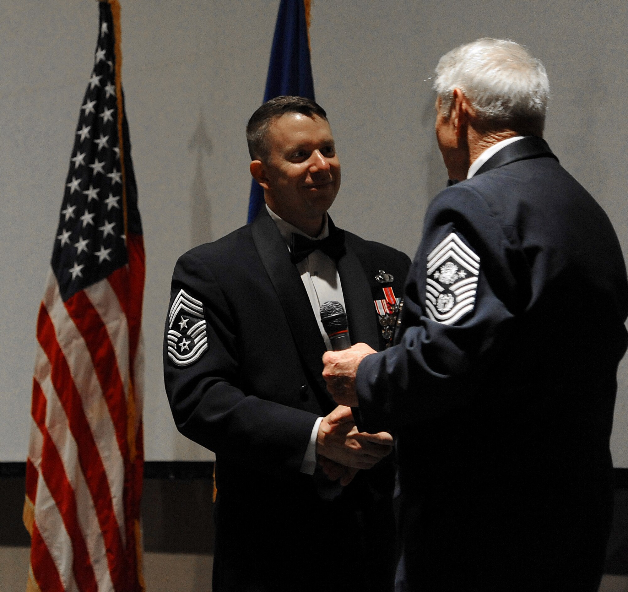 SAN ANGELO, Texas -- Chief Master Sgt. Brendan Criswell, 17th Training Wing Command Chief, hands the microphone to retired Chief Master Sgt. Robert D. Gaylor, the fifth Chief Master Sergeant of the Air Force, who was the guest speaker at Air Force Ball Sept. 16 at the McNease Convention Center. (U.S. Air Force photo/Airman 1st Class Michael Smith)