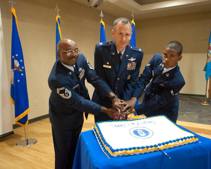U.S. Air Force Col. Billy Thompson, 23rd Wing commander, cuts a birthday cake alongside Senior Master Sgt. Eddie Taylor, 23rd Civil Engineer Squadron operations flight superintendent, and Airman 1st Class Kevin Serrano, 23rd Component Maintenance Squadron aircraft fuels systems apprentice, at the 64th Air Force birthday celebration at Moody Air Force Base, Ga., Sept. 16, 2011. Taylor and Serrano were chosen to cut the cake with Thompson because they are the oldest and youngest individuals at Moody. (U.S. Air Force photo by Airman 1st Class Paul Francis/Released)

