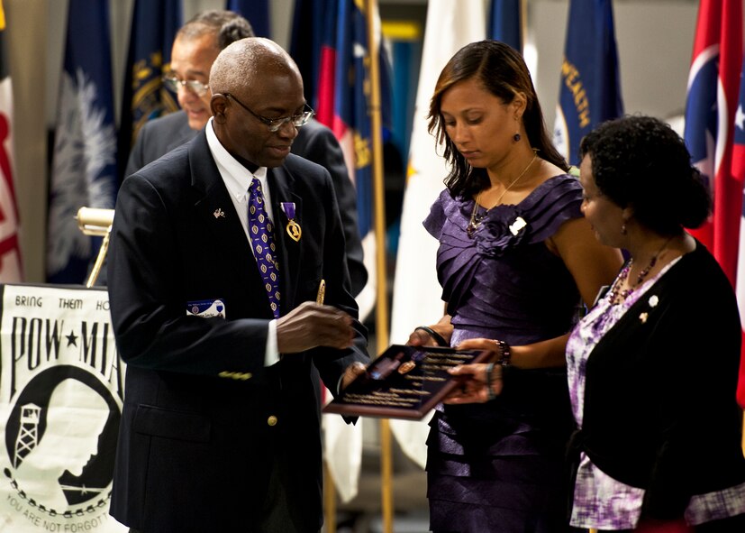 Col. Washington J. Sanchez Jr., the commander of the Florida department of the Military Order of the Purple Heart, presents a purple heart plaque to LaShana Douville, widow of Tech. Sgt. Daniel Douville, at the POW/MIA ceremony at the Air Force Armament Museum Sept. 16.  Douville was an explosive ordnance disposal technician from the 96th Air Base Wing, who was killed in Afghanistan earlier this year.  (U.S. Air Force photo/Samuel King Jr.)