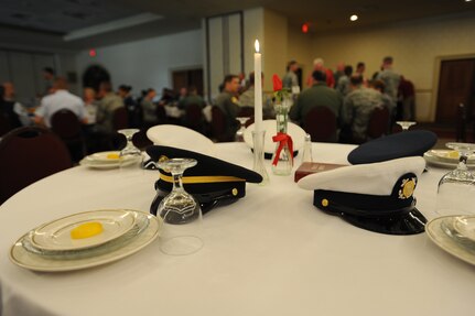 United States Navy, Air Force, Army, Marine Corps, and Coast Guard service hats rest on a Prisoner of War/Missing in Action table as part of a presentation during a POW/MIA luncheon Sept. 16 on Joint Base Charleston. The setting of the POW/MIA table is a time-honored ceremony in recognition of captured, killed in action and missing comrades from each service. More than 20 former POW's from throughout the state of South Carolina attended the event as honored guests. (U.S. Air Force photo/Staff Sgt. Katie Gieratz) (Released)