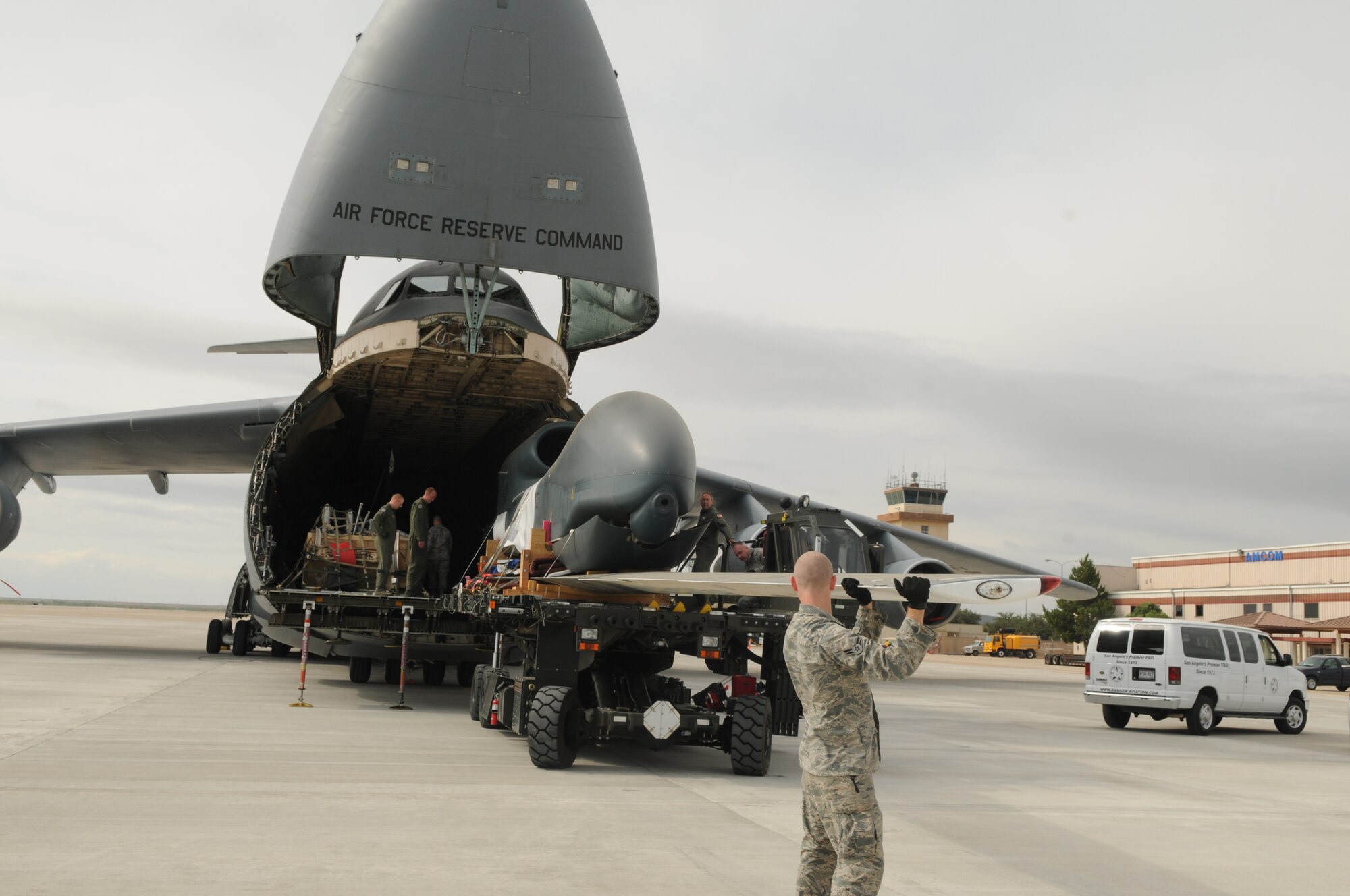 SAN ANGELO, Texas – Airman 1st Class Corey Travis, from the 97th Logistics Readiness Squadron, Altus Air Force Base, Okla., guides the wing of an RQ-4 Global Hawk as it is unloaded from a C-5 Galaxy, at San Angelo Regional Airport/Mathis Field, Sept 14. The aircraft transported two decommissioned RQ-4 Global Hawk drones from Beale Air Force Base, Calif. These drones are the first of their kind to be used as static displays, one of which will be at Goodfellow Air Force Base, Texas. (U.S. Air Force Photo /Senior Airman Heather L. Rodgers)