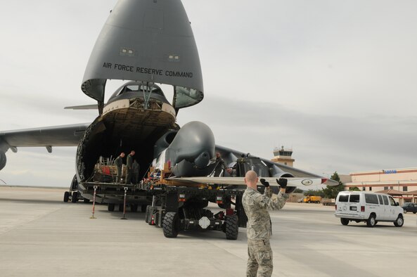 SAN ANGELO, Texas – Airman 1st Class Corey Travis, from the 97th Logistics Readiness Squadron, Altus Air Force Base, Okla., guides the wing of an RQ-4 Global Hawk as it is unloaded from a C-5 Galaxy, at San Angelo Regional Airport/Mathis Field, Sept 14. The aircraft transported two decommissioned RQ-4 Global Hawk drones from Beale Air Force Base, Calif. These drones are the first of their kind to be used as static displays, one of which will be at Goodfellow Air Force Base, Texas. (U.S. Air Force Photo /Senior Airman Heather L. Rodgers)