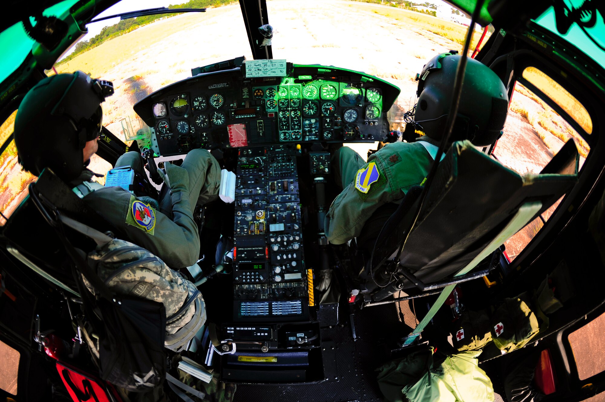 Tony Arrington (left) and Maj. Keith Friedman (right), 40th Flight Test Squadron helicopter aircrew, wait to take off in the UH-1 Huey at Eglin Air Force Base, Fla., Sept. 15.  During the training, they practiced flying with and delivering 600 pounds of cargo.  (U.S. Air Force photo/Staff Sgt. Joely Santiago)