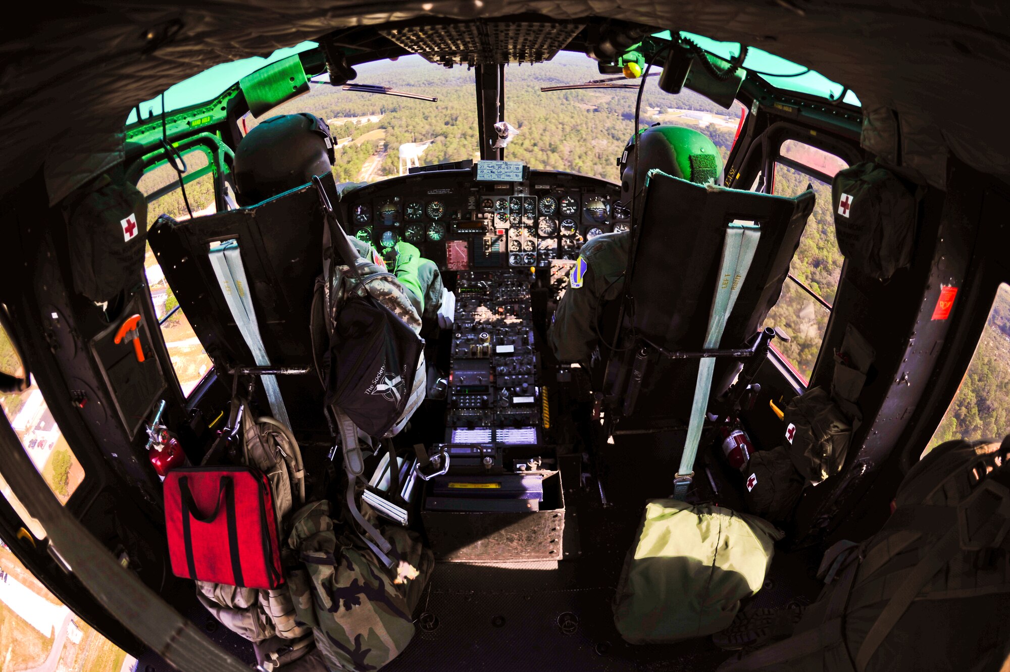 Tony Arrington (left) and Maj. Keith Friedman (right), 40th Flight Test Squadron helicopter aircrew, fly the UH-1 Huey over ranges at Eglin Air Force Base, Fla., Sept. 15.  During the training, they practiced flying with and delivering 600 pounds of cargo.  (U.S. Air Force photo/Staff Sgt. Joely Santiago)