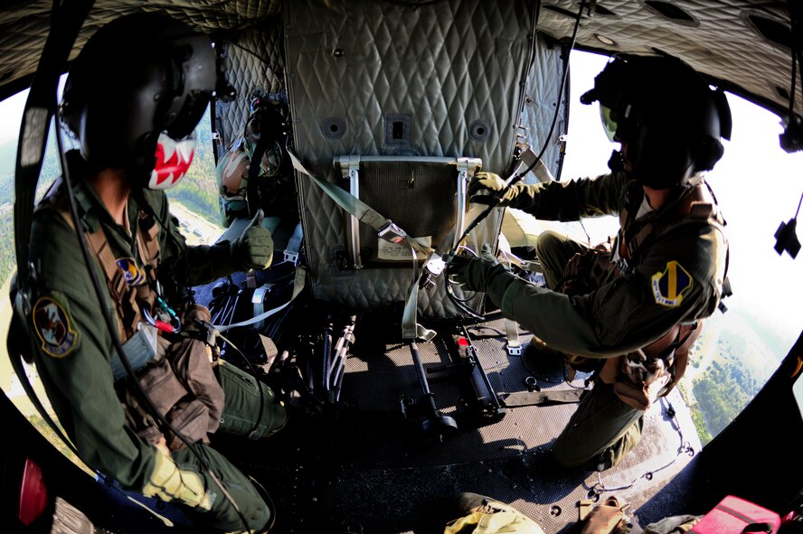 Tech. Sgts. Jaime Aulbach (left) and James Kempfer (right), from the 40th Flight Test Squadron, secure a seat on the UH-1N Huey in preparation of rope ladder training Sept. 15.  The training was flown over ranges on Eglin Air Force Base, Fla. (U.S. Air Force Photo/Staff Sgt. Joely Santiago)