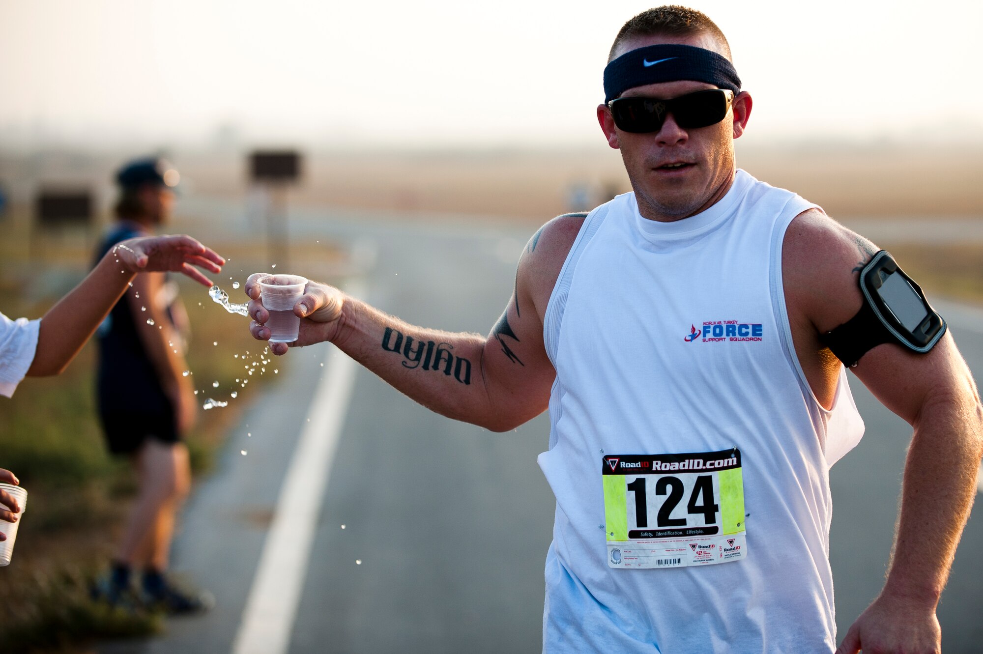 Davis Conn, 728th Air Mobility Squadron, grabs a cup of water during the half marathon Sept. 17, 2011, at Incirlik Air Base, Turkey. More than 80 runners participated in the 13.1 mile race that coincided with the annual Air Force Marathon. Conn finished the run in 2:06:58. (U.S. Air Force photo by Tech. Sgt. Michael B. Keller/Released)
