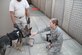 Maj. Jessica Haugland, 838th Air Expeditionary Advisory Group, pets a working dog stationed at Shindand Air Base. Because of extreme weather conditions on base, Haugland made contact with a stateside working dog organization who willingly donated enough cooling vests for all base working dogs and handlers. (U.S. Air Force courtesy photo)