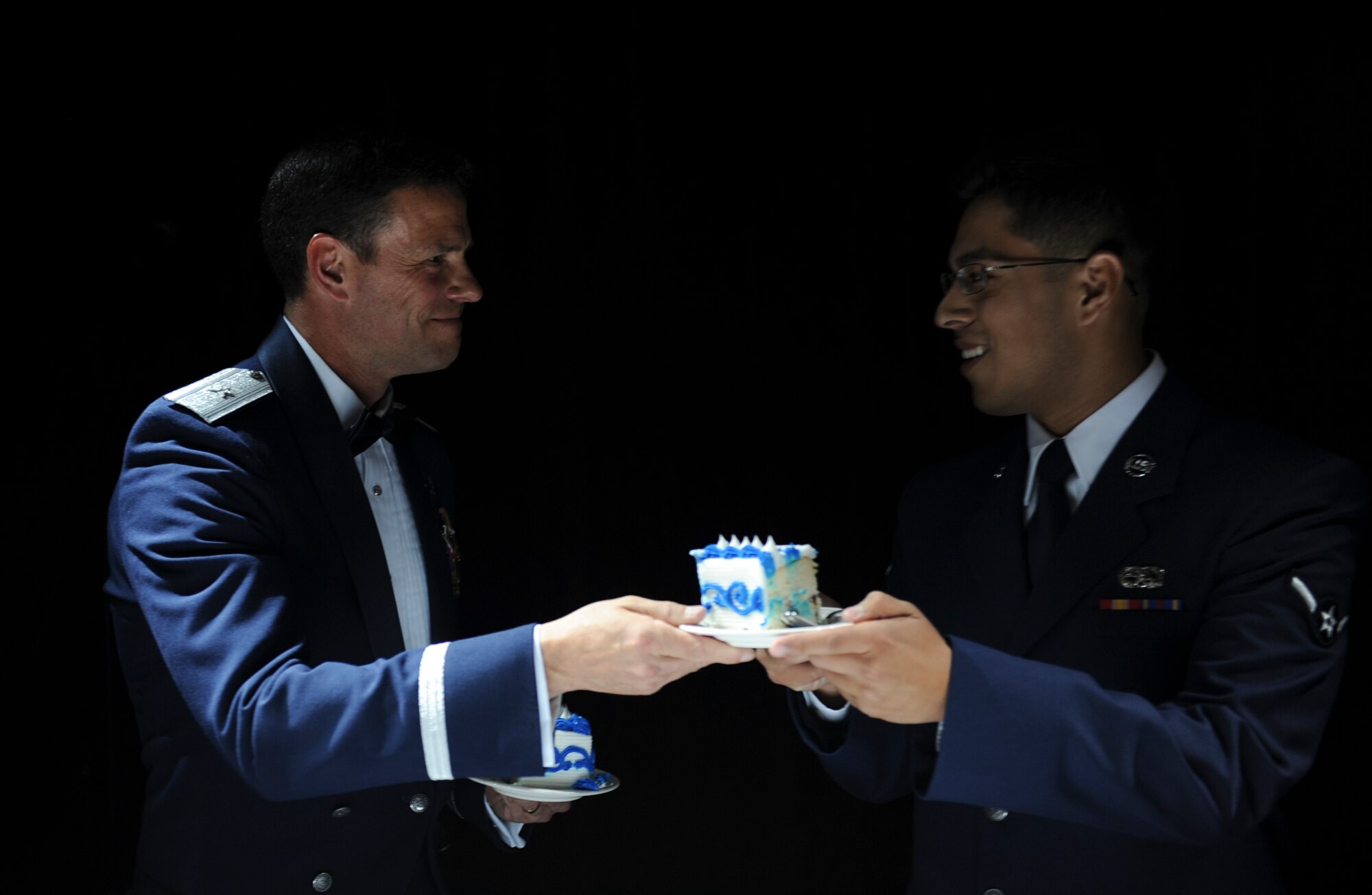 In the spirit of Air Force tradition, 18th Wing commander, Brig. Gen. Mathew Malloy hands Airman Roy De Jesus, 18th Communications Squadron, a piece of birthday cake during Kadena’s Air Force Ball at the NCO Club, Sept. 17, 2011. As per tradition, the oldest and youngest present Airman are the two that cut the cake. (U.S. Air Force photo by Airman 1st Class Brooke P. Beers)