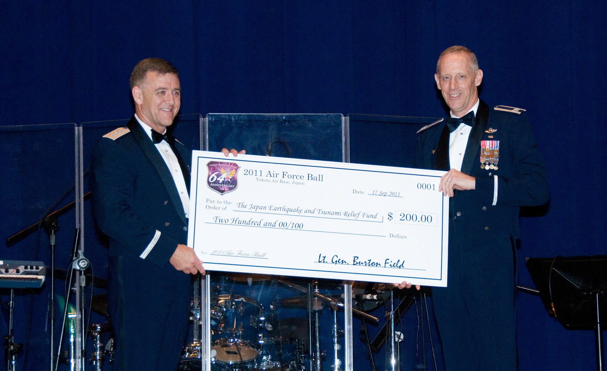 YOKOTA AIR BASE, Japan -- Col. Otto Feather, 374th Airlift Wing commander, presents a check to Lt. Gen. Burton Field, commander of U.S Forces, Japan, and 5th Air Force, during the Air Force Ball at Yokota Air Base, Sept. 17, 2011. The $200 check is a donation to the Japan Earthquake and Tsunami Relief Fund on behalf of the General for being the guest speaker at the event. (U.S. Air Force photo/Airman 1st Class Krystal M. Garrett) 