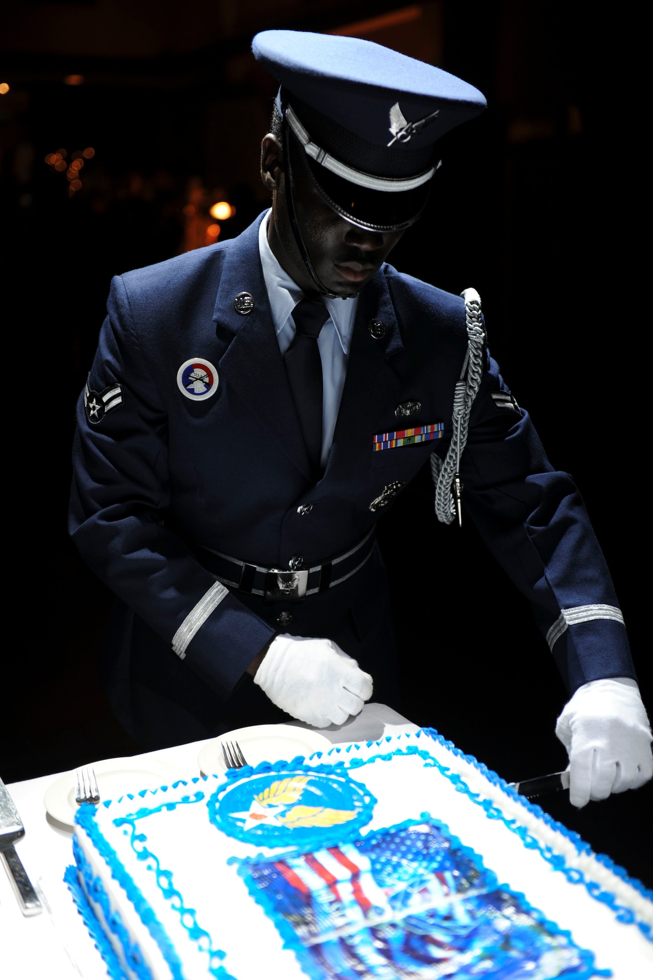 Airman 1st Class Richard R. Blackman, 18th Security Forces and Honor guardsman, cuts a piece of Air Force birthday cake during Kadena's Air Force Ball at the Rocker NCO club on Sept. 17, 2011. The Air Force Ball was held in honor of the Air Force's 64th birthday and is a night to celebrate our great heritage and those that came before us. (U.S. Air Force photo by Airman 1st Class Brooke P. Beers)