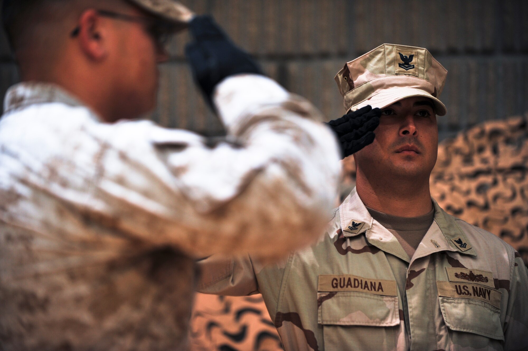 Petty Officer 2nd Class Aaron Guadiana, Combined Forces Special Operations Component Command firefighter, salutes during a prisoners of war, missing in action ceremony at a 64th Air Force birthday dinner, Sept. 18, 2011, at an undisclosed location in Southwest Asia. Guadiana, a native of San Diego, Calif., is deployed from 32nd Naval Base in San Diego. (U.S. Air Force photo/Senior Airman Paul Labbe)