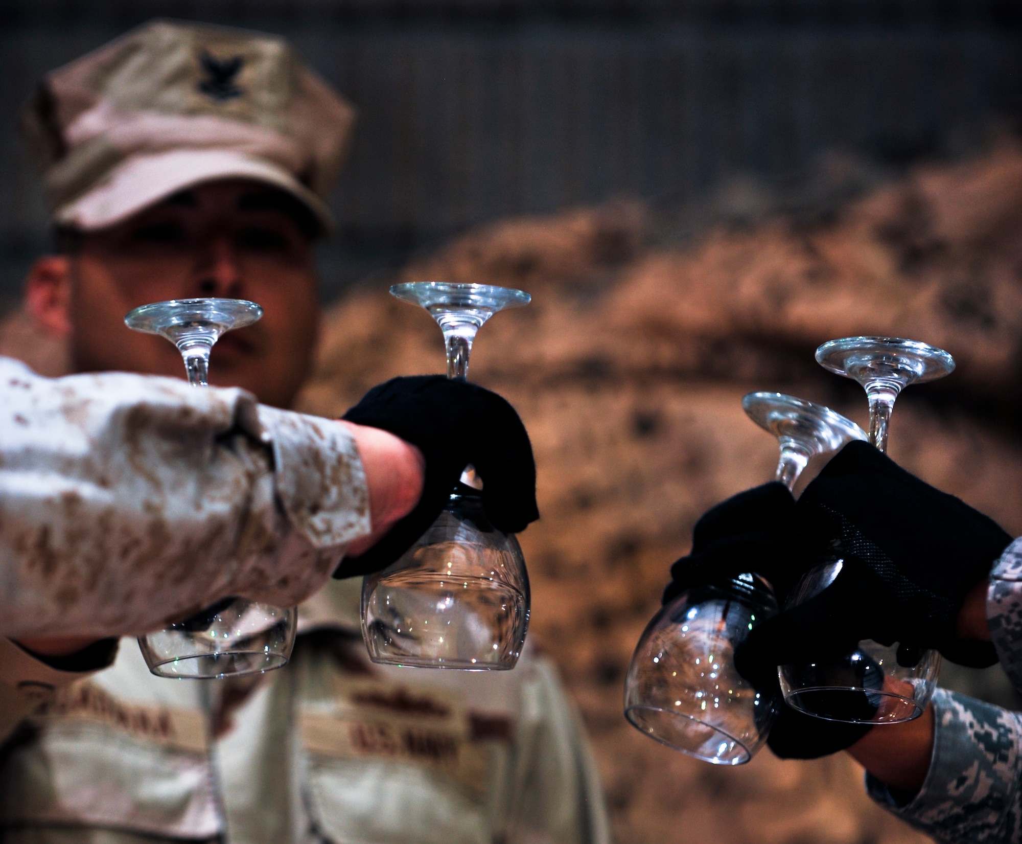 Servicemembers representing the Army, Marine Corps, Navy and Air Force perform a fallen comrade ceremony during a 64th Air Force birthday dinner, Sept. 18, 2011, at an undisclosed location in Southwest Asia. The glasses are inverted to symbolize that fallen comrades, those currently held as prisoners of war and those missing in action cannot toast with everyone in attendance at the dinner. (U.S. Air Force photo/Senior Airman Paul Labbe)