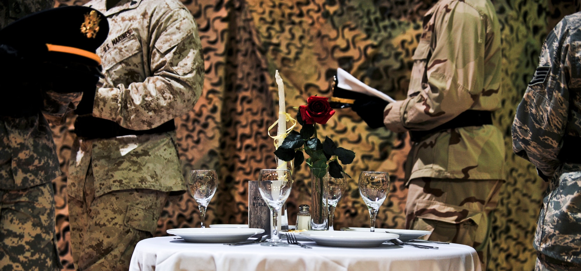 Servicemembers representing the Army, Marine Corps, Navy and Air Force march around a table during a fallen comrade ceremony during a 64th Air Force birthday dinner, Sept. 18, 2011, at an undisclosed location in Southwest Asia. The table was reserved to honor the brave and selfless American military members who have perished on the battlefield, those who have not been returned after being taken prisoner on foreign soil and for those who went missing and have not found their way back home. The table symbolizes that while all of those Americans could not physically be at the dinner, they were there in spirit. (U.S. Air Force photo/Senior Airman Paul Labbe)