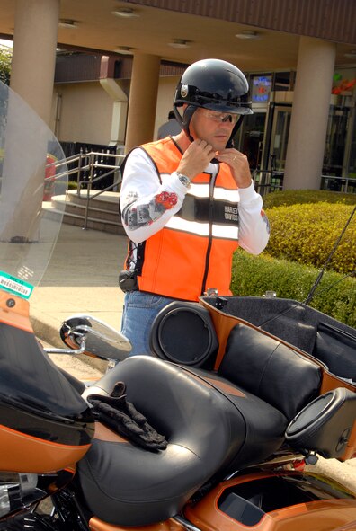 Chief Master Sgt. Deno Mackin, 51st Fighter Wing Command Chief, straps on his helmet before embarking on a 75-mile safety ride Sept. 14. The safety ride reinforces basic riding skills and increases familiarity with local riding conditions, reducing the chances for a motorcycle-related injury or death. (U.S. Air Force photo/Tech. Sgt. Eric Petosky)