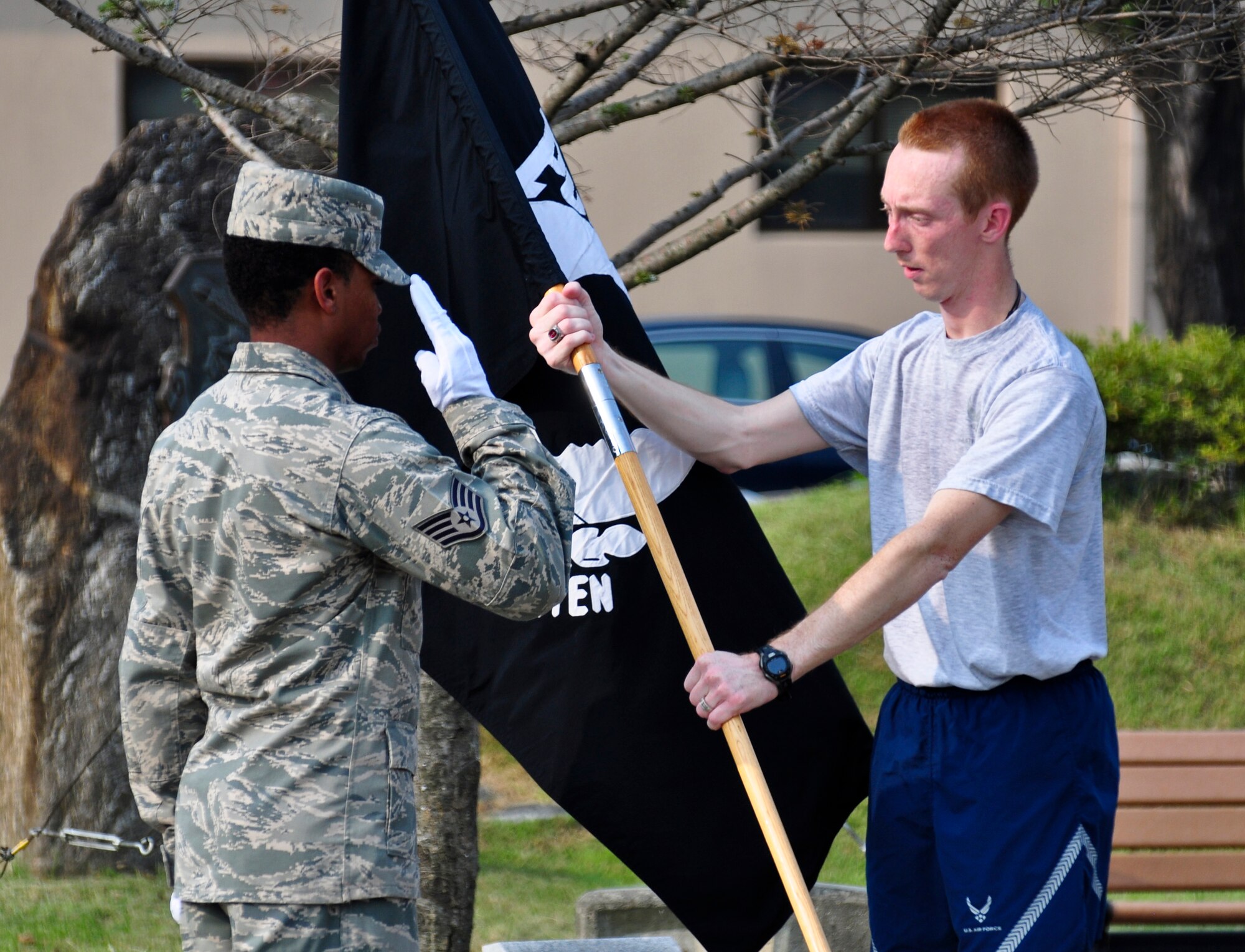 An Airman hands off the POW/MIA flag during POW/MIA Recognition day Sept. 16, 2011 at the POW/MIA Memorial in front of the base theater. Members of the Osan’s Air Force Sergeants Association honored all POW/MIAs during several ceremonies and events Sept. 12-16. (U.S. Air Force photo/Tech. Sgt. Chad Thompson)