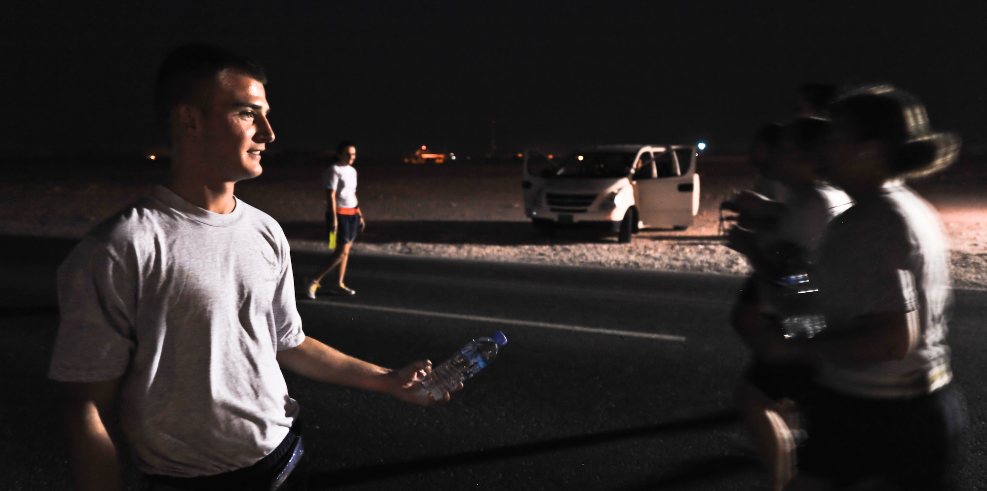 Senior Airman Vincent Chapman, 379th Expeditionary Maintenance Squadron avionics technician, hands out water to runners participating in 64th Air Force birthday 10K and half-marathon races, Sept. 17, 2011, at an undisclosed location in Southwest Asia. Chapman, a native of Jacksonville, Fla., is deployed from Joint Base Charleston, S.C. (U.S. Air Force photo/Senior Airman Paul Labbe)