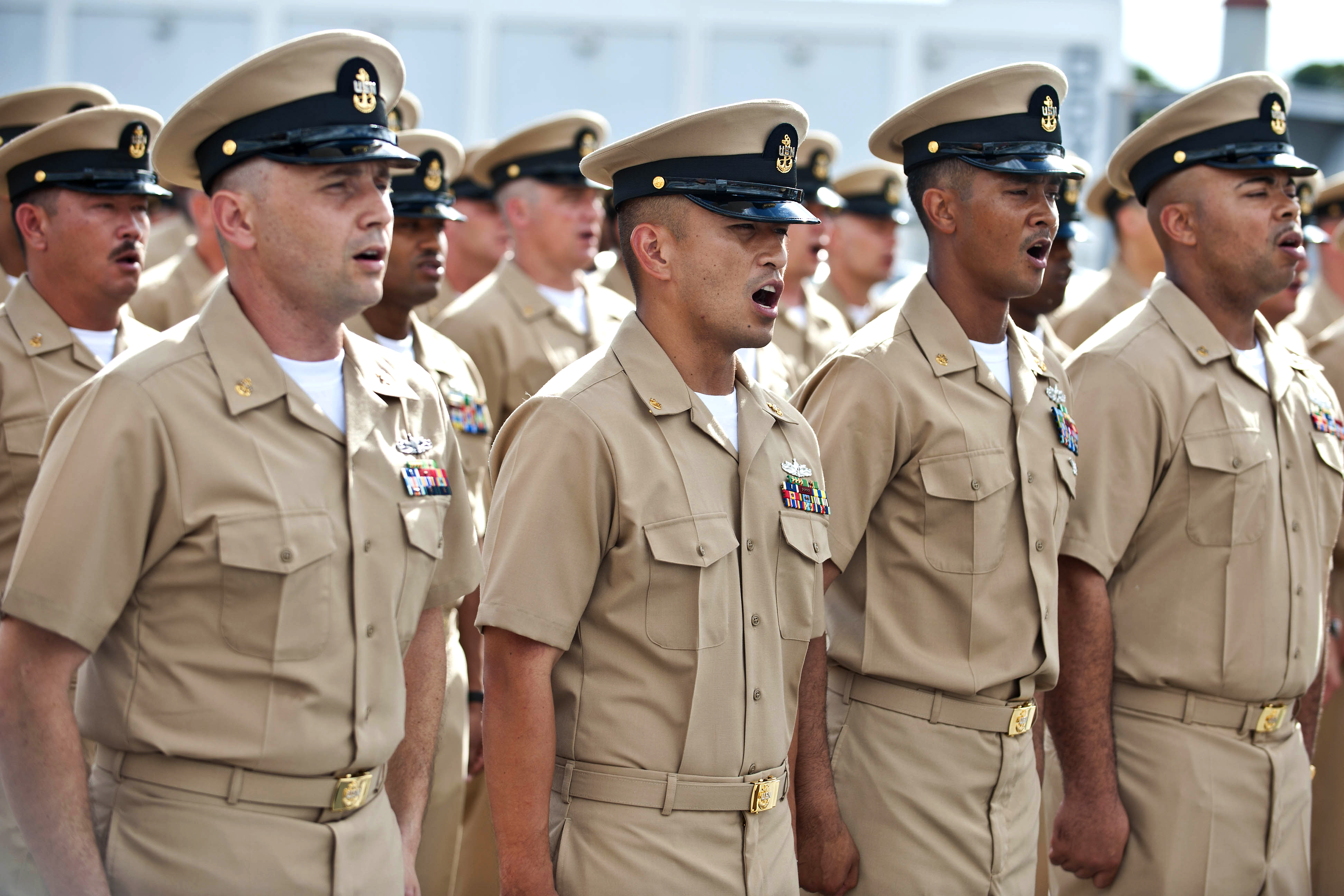 Newly-pinned chief petty officers sing Anchors Away during the U.S. 7th  Fleet Chief Petty Officer