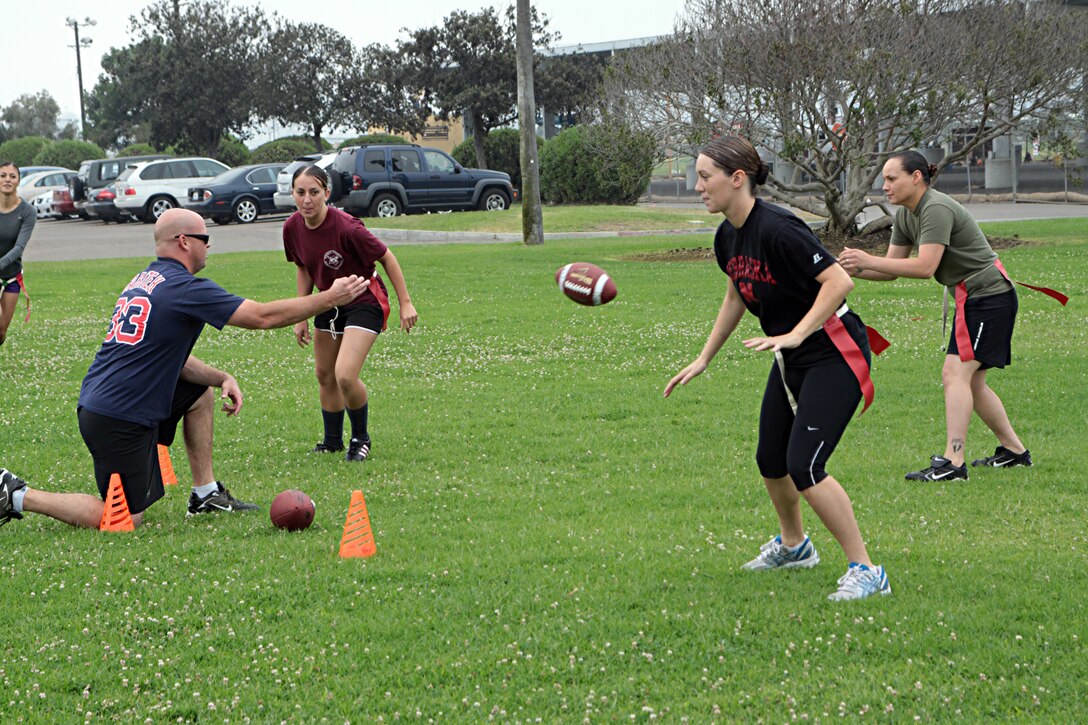 The Headquarters and Service Battalion powder puff football team reviews their offensive plays during practice Monday. The team is coached by 1st Sgt. Charles Callahan and Staff Sgt. Hector Alanis.