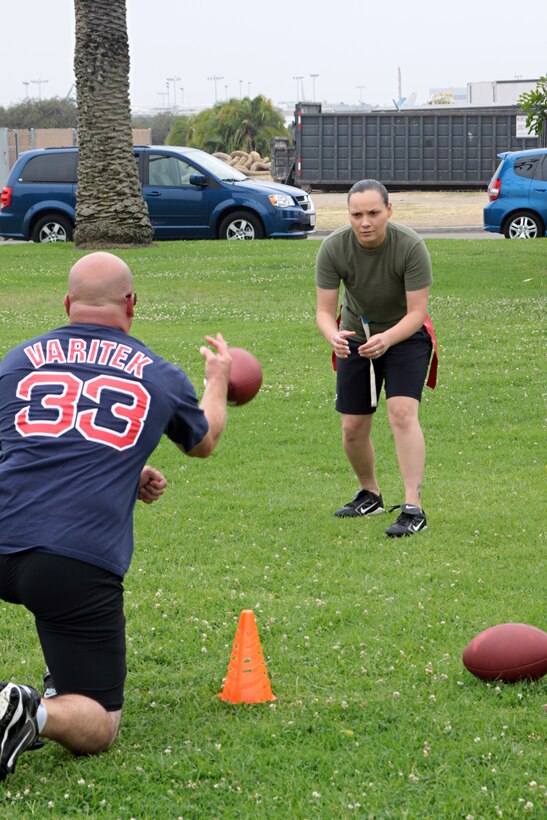 Sgt. Keonaona Paulo, quarterback for the Headquarters and Service Battalion powder puff football team, receives a snap during practice Monday from coach 1st Sgt. Charles Callahan. H&S won the championship last year and is preparing to defend that title again this year.