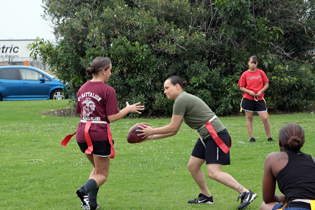 Sgt. Keonaona Paulo, quarterback for the Headquarters and Service Battalion powder puff football team, pitches the ball to another teammate while running an offensive play during practice Monday. This year's powder puff tournament will be held here Oct. 18-19.