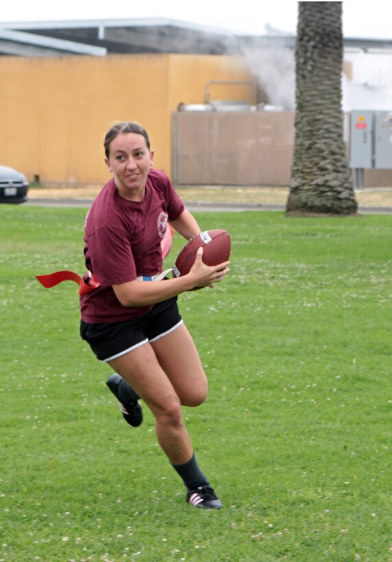 Sgt. Amanda Mazzei, halfback for the Headquarters and Service Battalion powder puff football team, makes a run after receiving the ball during a practice scrimmage Monday. The team will be defending their title in the tournament to be held here Oct. 18-19.