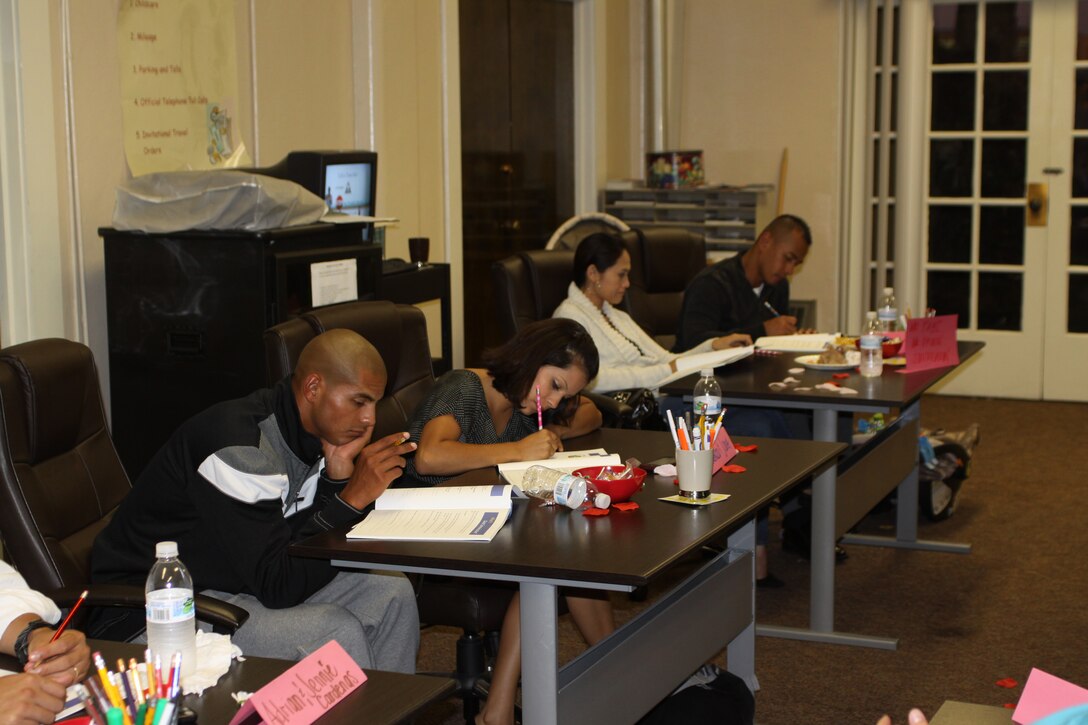 Couples fill out their workbooks at the Prevention and Relationship Enhancement Program aboard Marine Corps Recruit Depot San Diego Sept. 19. The classroom was set up to represent a date night with dimmed lights, flower petals, dinner and child care.
