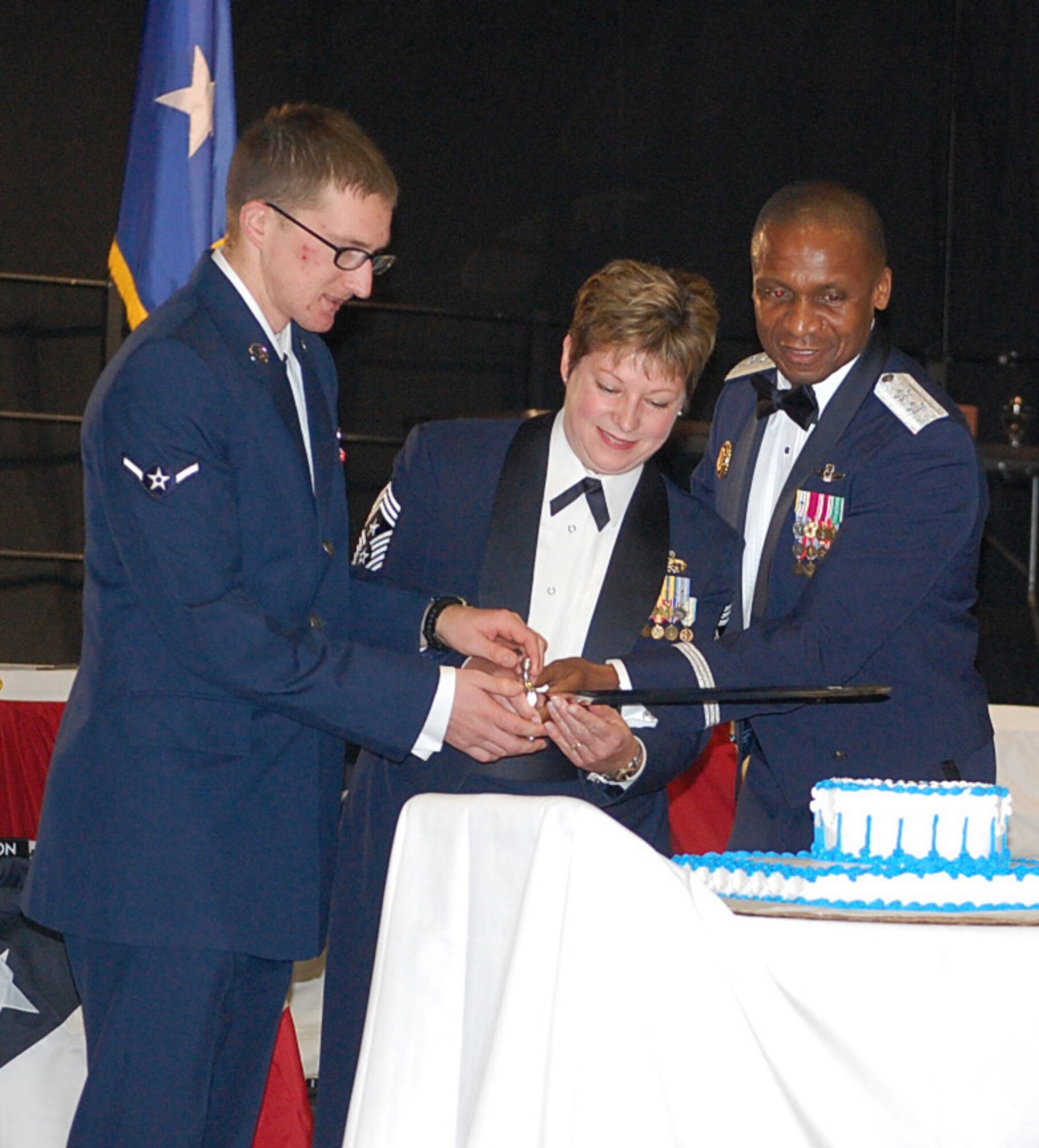 Amn. Matthew Baisley (left to right), Chief Master Sgt. Gloria Bennett, and Maj. Gen. Darren McDew join forces to cut the cake at the Air Force Birthday Ball Sept. 17.  McDew was the guest speaker and serves as commander, Air Force District of Washington, Andrews Air Force Base, Md.  Baisley, 62nd Aerial Port Squadron, represents the most junior Airman in attendance, and Bennett, 446th Airlift Wing command chief, represents the most senior Airman at the Air Force Ball held in Hangars 3 and 4, McChord Field, Wash. More than 40 Reservists attended this year's ball, double the previous year. (U.S. Air Force photo by TSgt. Jennifer Bargiel) 