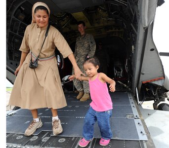 Sister Edith Suazo, an orphanage caregiver, holds the hand of Maria Jose, a San Jose orphan, after exploring the inside of a Chinook helicopter Sept. 17, 2011 at Soto Can Air Base, Honduras. Children from the nearby orphanage visited Joint Task Force-Bravo members to play soccer, brake open piñatas, and swim in the base pool. (U.S. Air Force photo/Tech. Sgt. Matthew McGovern))