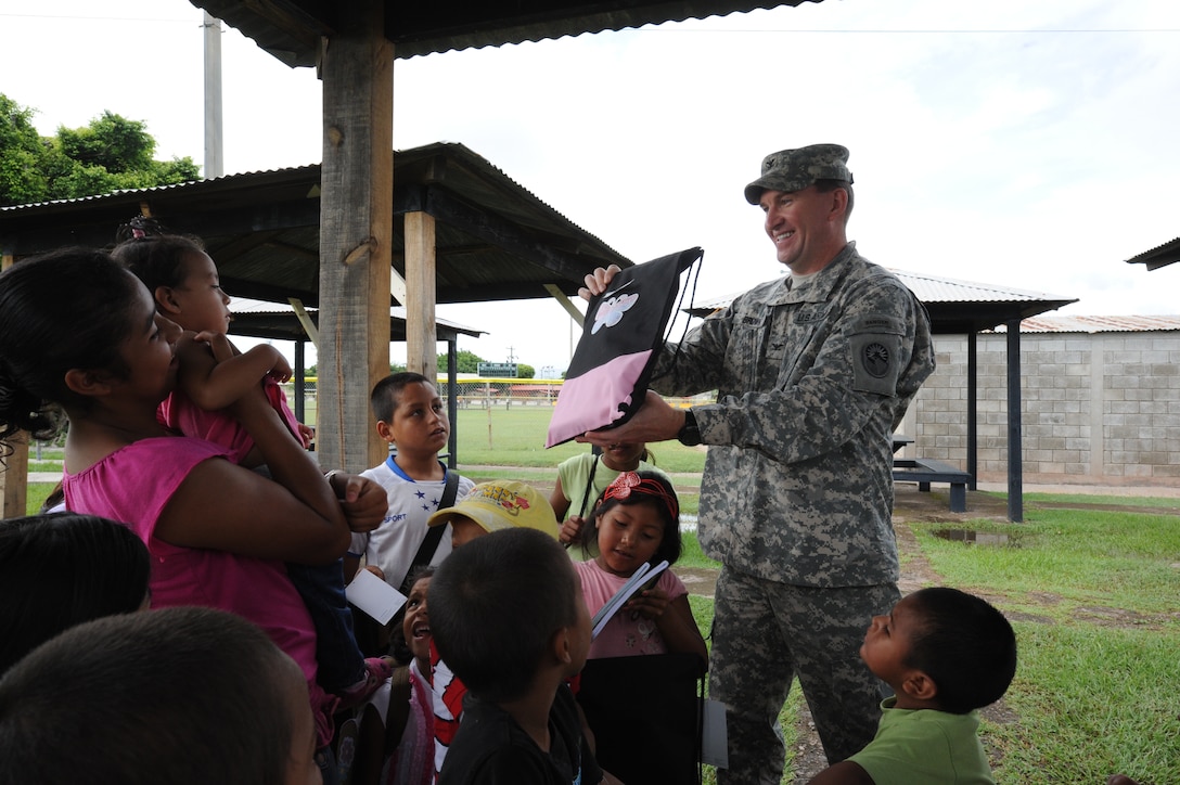 Col. Ross Brown, Joint Task Force-Bravo commander, gives backpacks filled with school supplies to 17 children form a local orphanage Sept. 17, 2011 during their visit to Soto Can Air Base, Honduras. (U.S. Air Force photo/Tech. Sgt. Matthew McGovern)